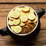 Do čeho investovat v období krize? Na obrázku měšec plný zlatých mincí